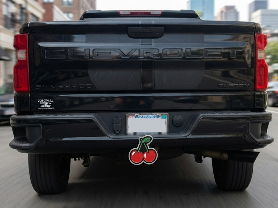 Cherries hitch cap mounted on a black truck's receiver hitch